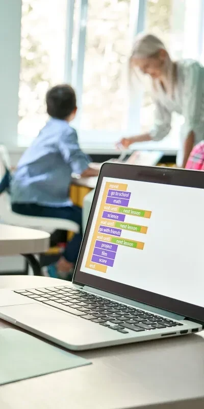 Laptop met docent op de achtergrond